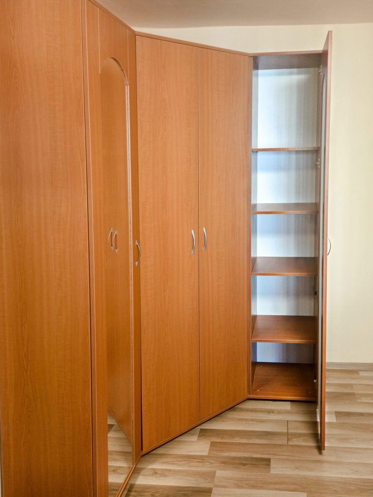 Corpul drept al dressingului pe colț, cu ușă clasică ce are inserție de sticlă sablată și interior cu rafturi.