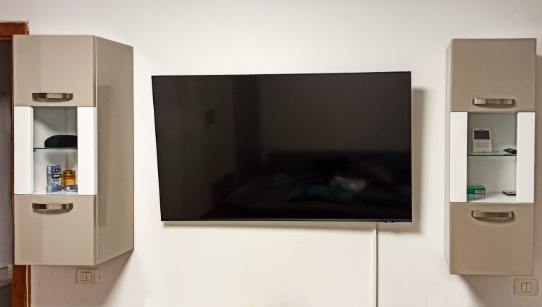 Corpuri suspendate din MDF lucios bej, cu mânere metalice și polițe interioare din sticlă, parte dintr-un mobilier de living modern realizat în Timișoara.