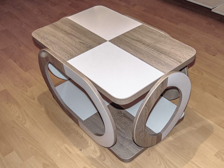 Măsuță de cafea cu design modern, cu blat în model șah de alb și stejar, și laterale ovale bicolore, creată la comandă.