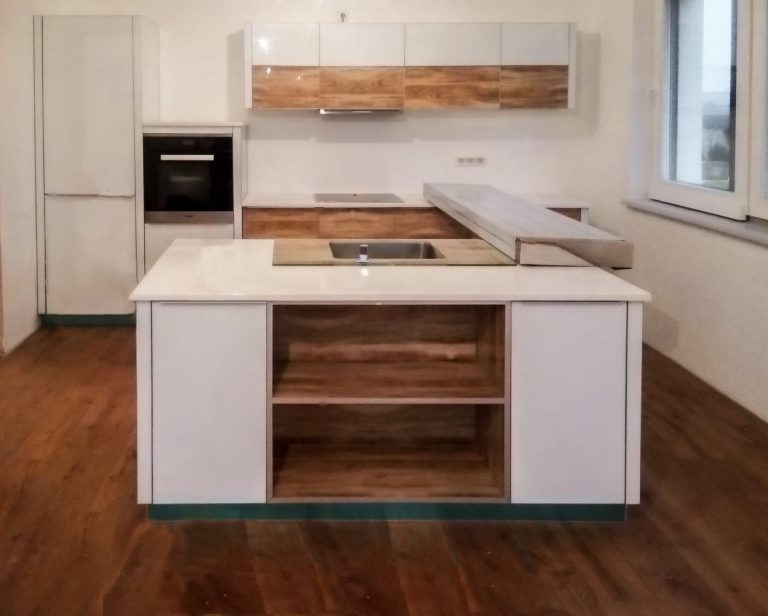 Bucătărie albă modernă cu insulă, văzută din living, cu rafturi decorative din sticlă cu finisaj de lemn care adaugă căldură vizuală.