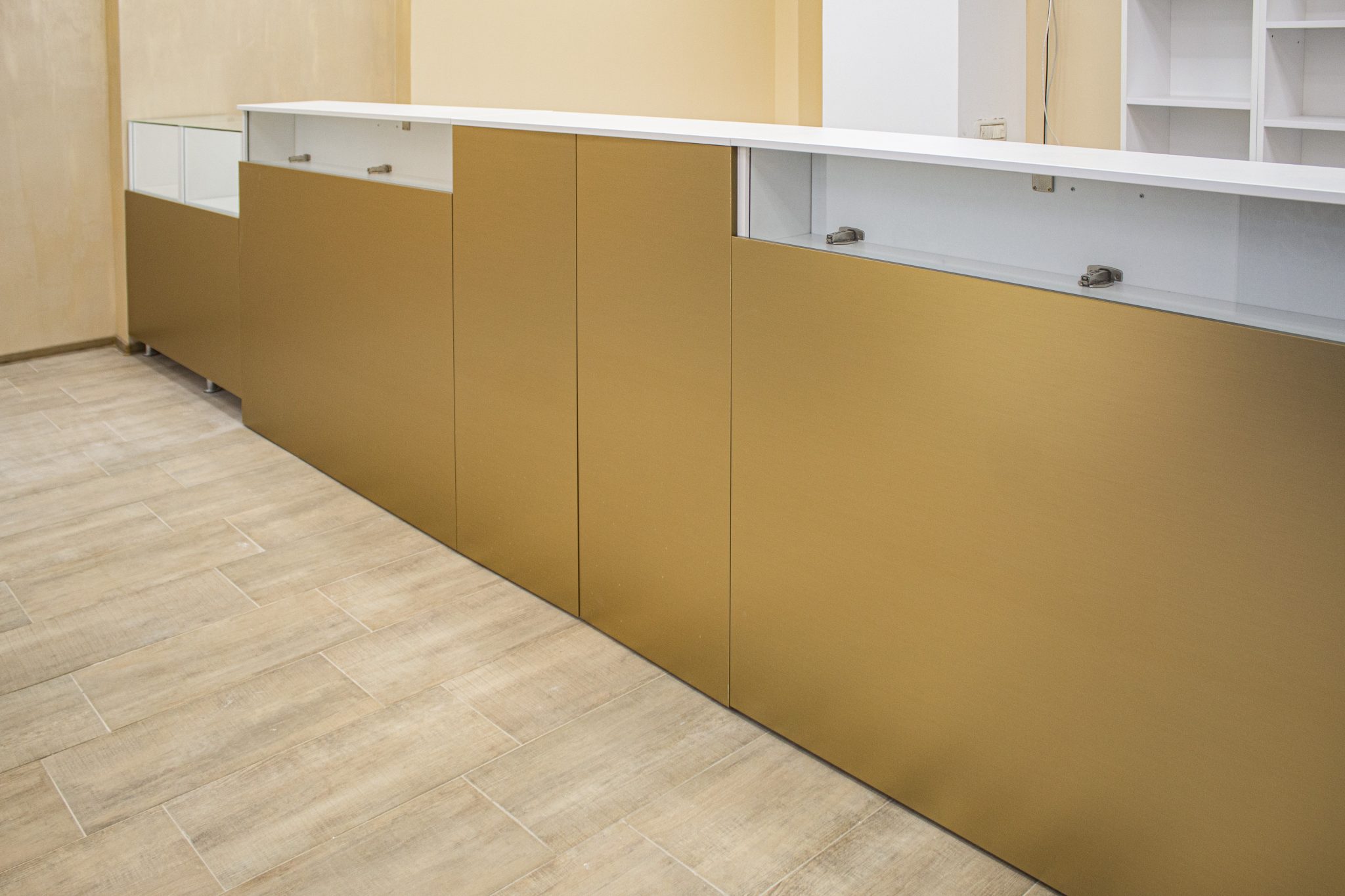 Detaliu front tejghea din MDF cu foaie metalică aurie lucioasă, mobilier comercial premium