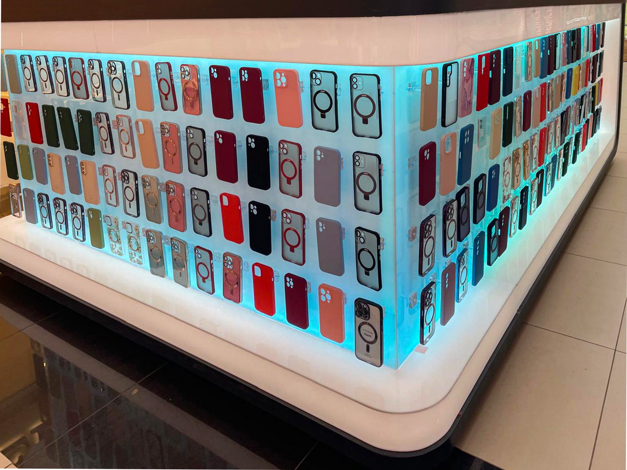 Prim-plan colț curbat insulă mall cu huse telefon pe fundal iluminat LED