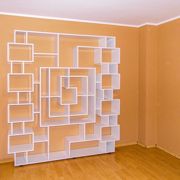 Etajeră albă de perete cu design contemporan, prezentând o compoziție de nișe și cadre asimetrice pentru decor.