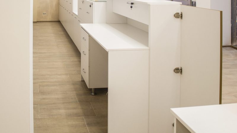 Ansamblu mobilier comercial alb mat, incluzând birou operator și corpuri joase de depozitare