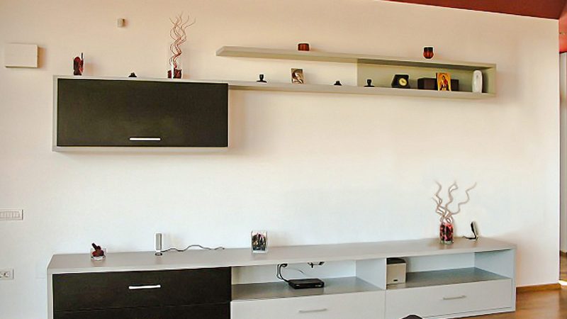 O altă perspectivă a mobilierului de living modern, care arată corpurile suspendate și comoda joasă din PAL.