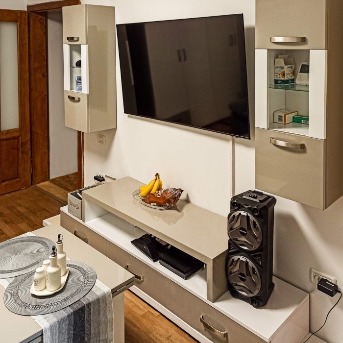 Imagine de ansamblu cu mobilier de living modern, în culorile bej și alb lucios, realizat la comandă în Timișoara, cu design simetric.