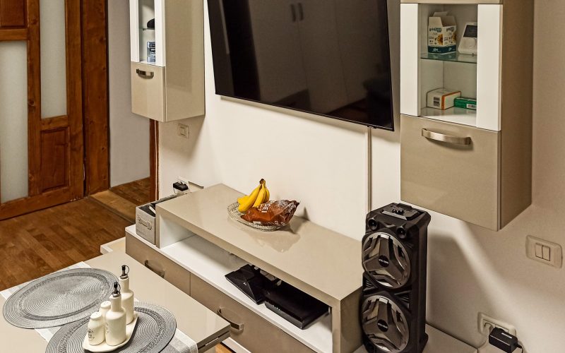 Imagine de ansamblu cu mobilier de living modern, în culorile bej și alb lucios, realizat la comandă în Timișoara, cu design simetric.