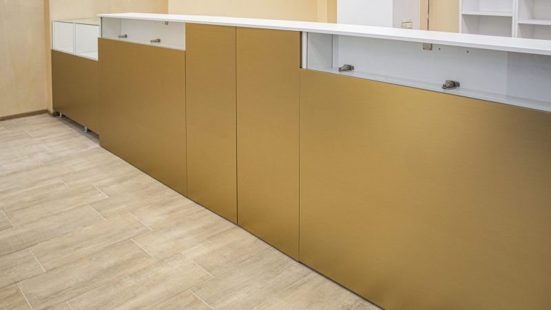 Detaliu front tejghea din MDF cu foaie metalică aurie lucioasă, mobilier comercial premium