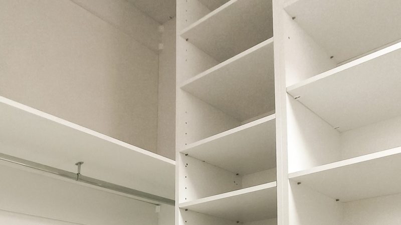 Secțiune de dressing pe comandă cu două bare de haine suprapuse pentru maximizarea spațiului și o coloană cu polițe cu înălțime reglabilă.