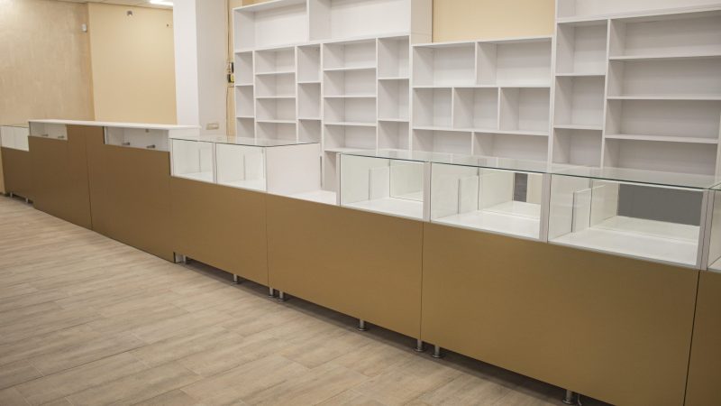 Linie de vitrine de expunere din sticlă securizată, integrate în tejgheaua cu front MDF auriu