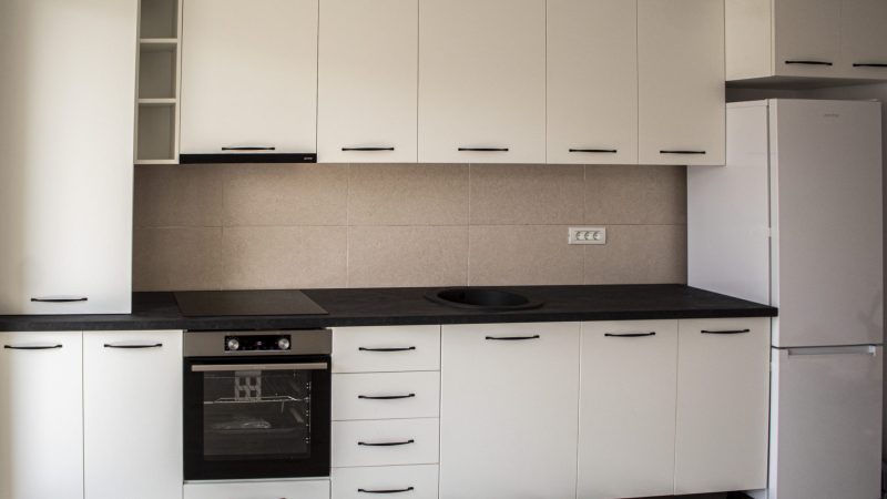 Imagine frontală, cu un ușor zoom, a corpurilor de mobilier din PAL melaminat alb, accentuând simetria și aliniamentul designului.