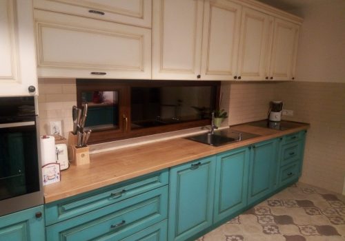 Mobilier Bucătărie MDF Vopsit Turcoaz și Crem Contrast cromatic între corpurile inferioare din MDF vopsit turcoaz și dulapurile superioare crem într-o bucătărie stil farmhouse.
